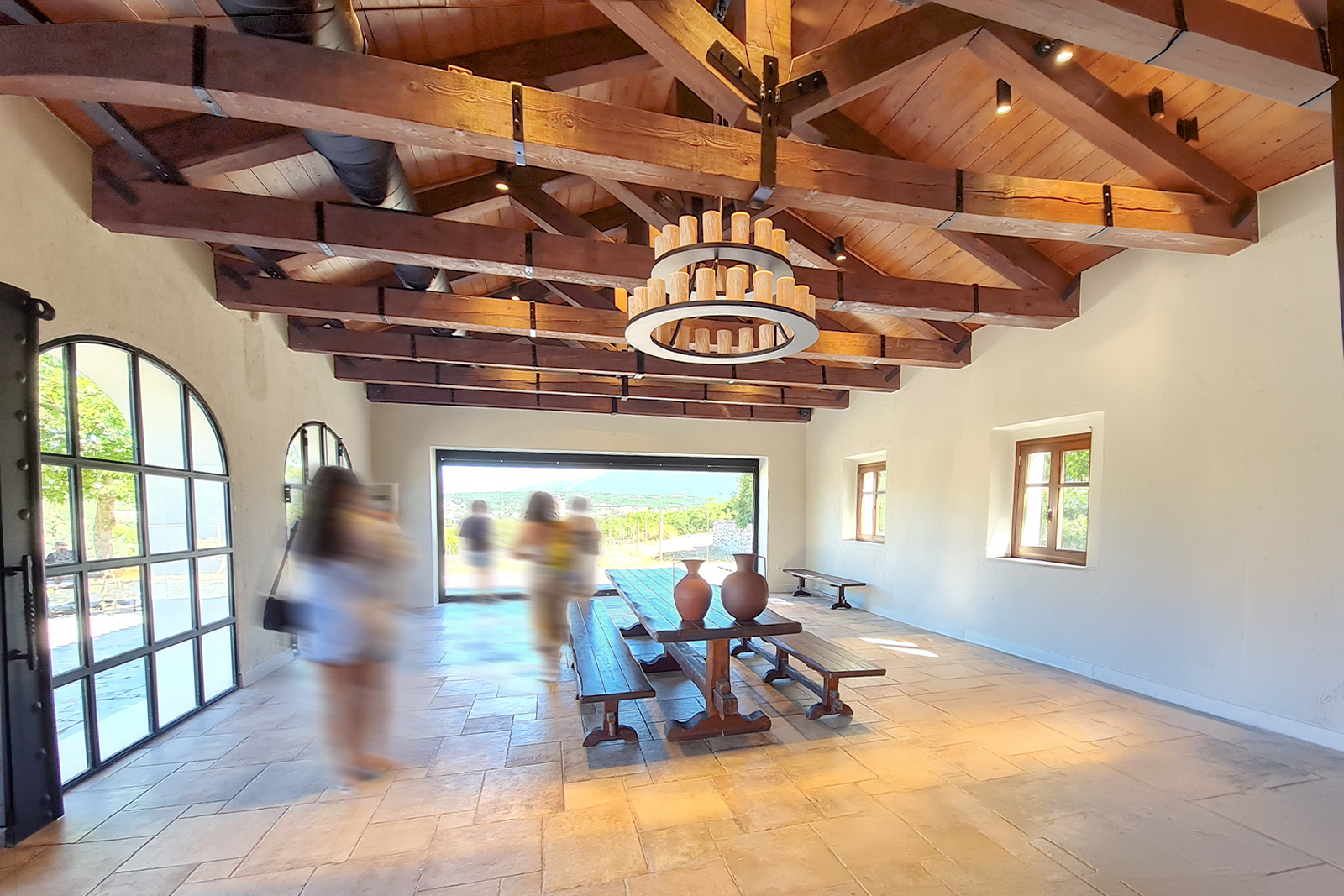 Sala accoglienza di una struttura ricettiva con luce naturale e persone in movimento — contenuti visivi autentici per B&B e realtà locali