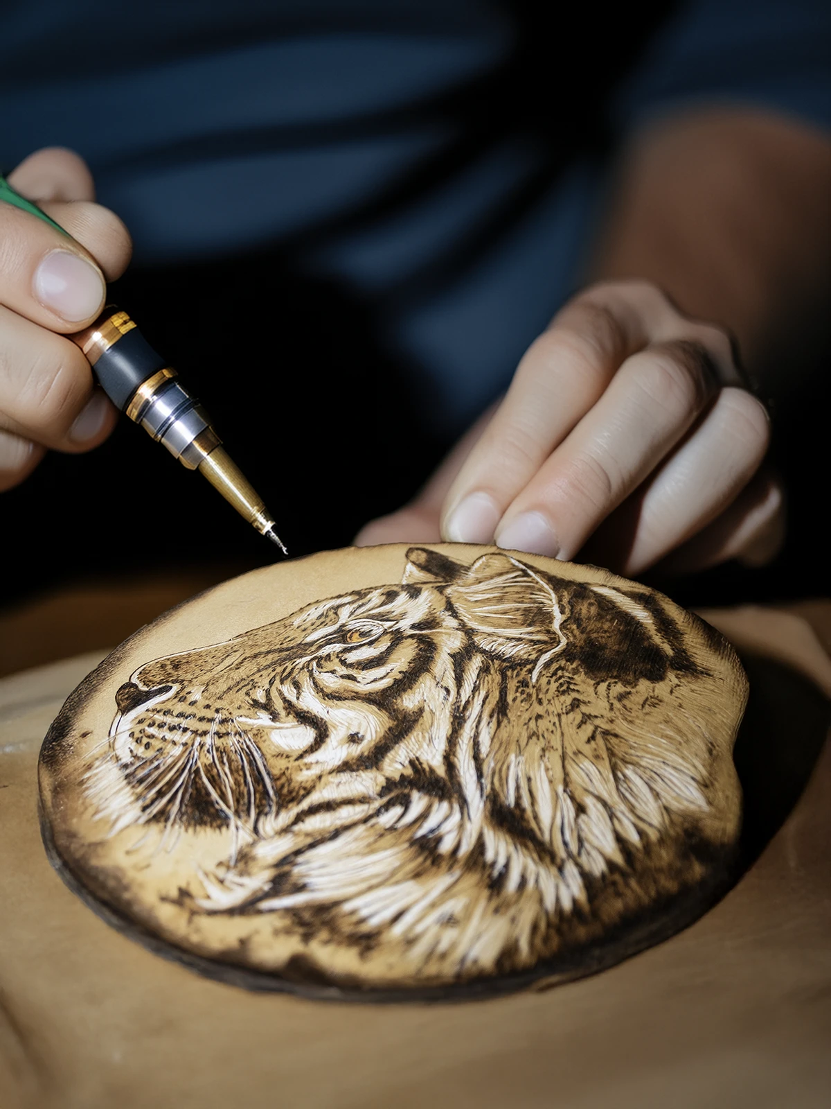 Mani che tracciano col pirografo il profilo di una tigre su legno grezzo — pirografia artigianale su legno, Appennino emiliano